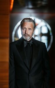 Mads Mikkelsen posing on the red carpet during an international film festival.