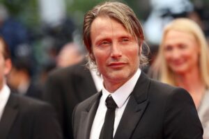 Mads Mikkelsen attending an international film premiere in a tailored black suit.